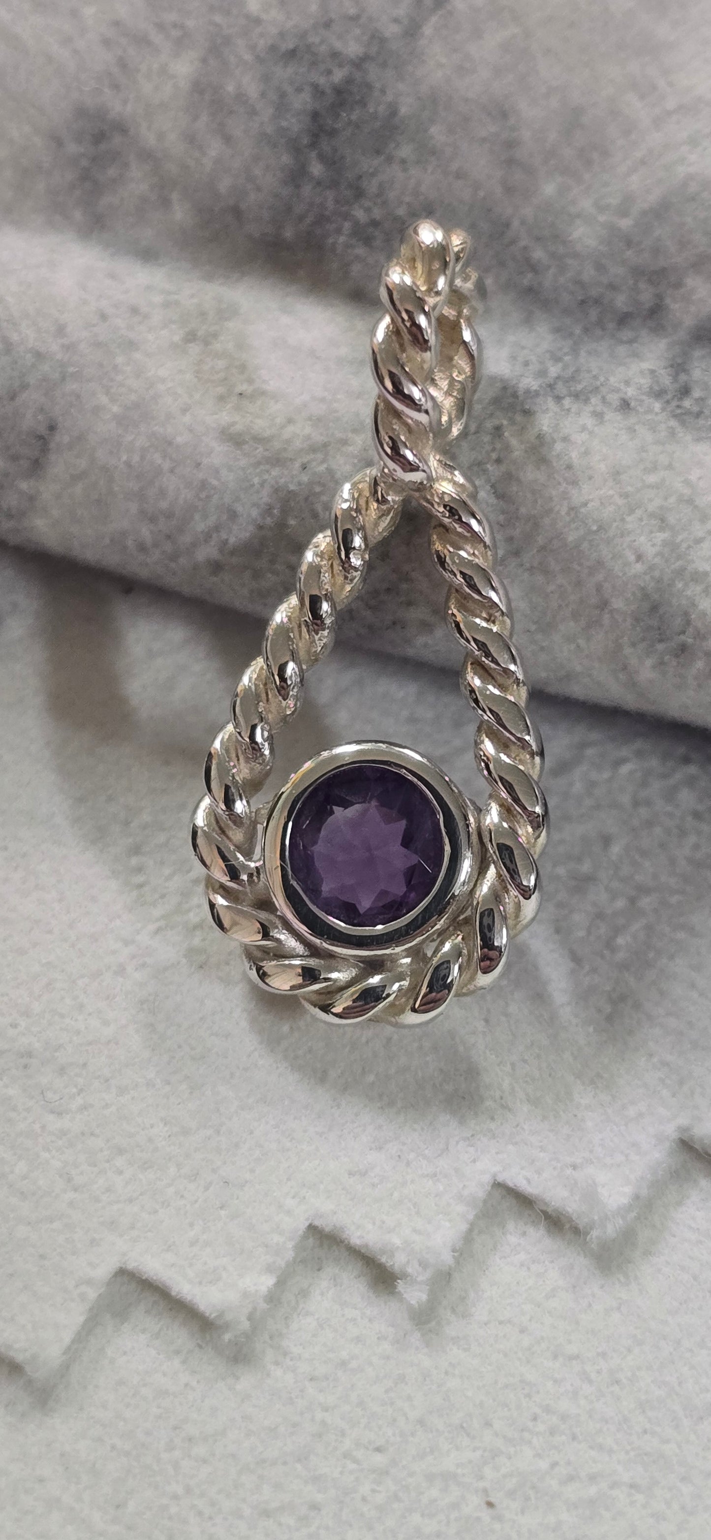 Twisted teardrop presenting a 5mm Amethyst silver mounting.