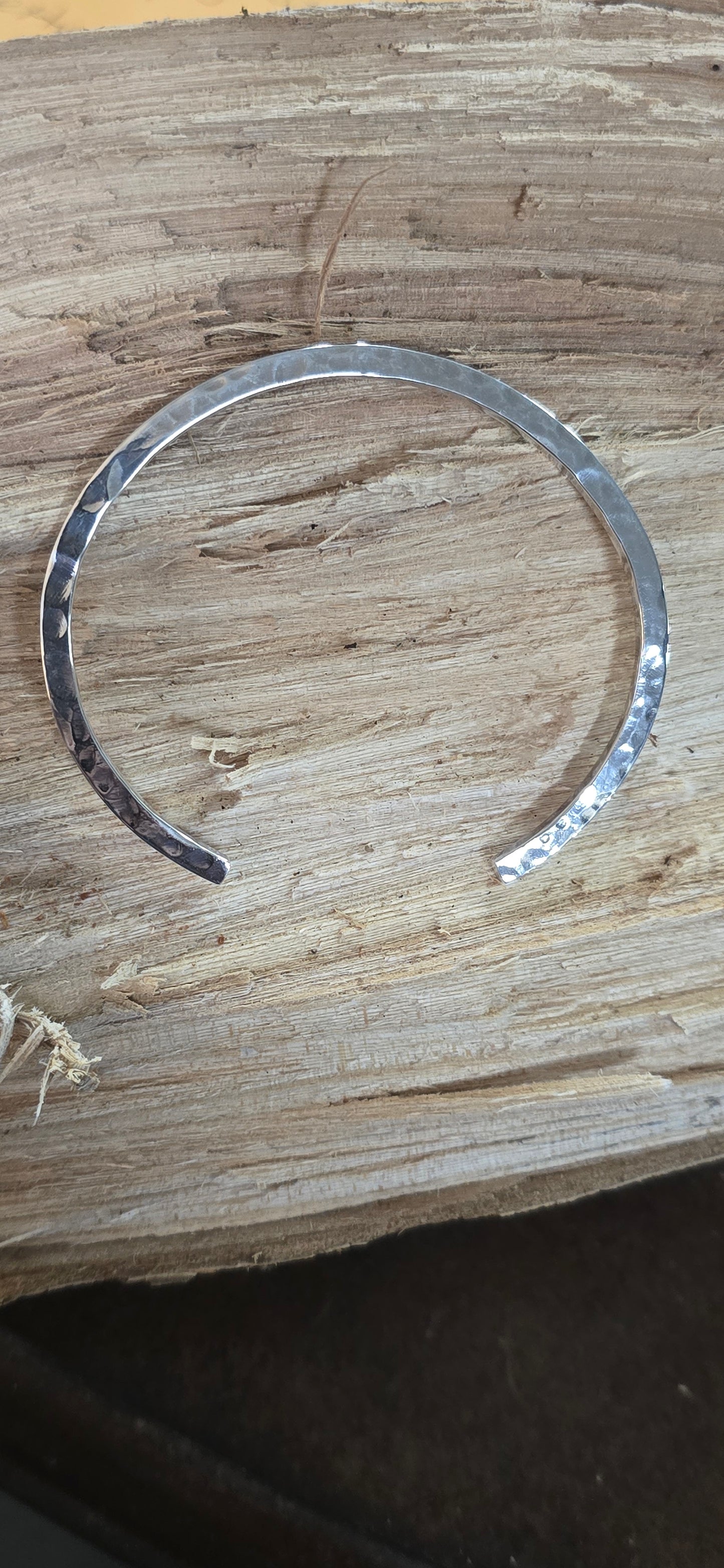 Hammered sterling  silver bracelet on the side smooth on the top.