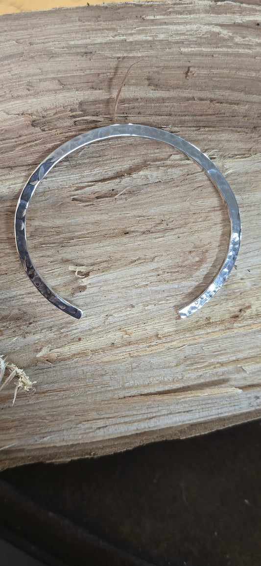 Hammered sterling  silver bracelet on the side smooth on the top.