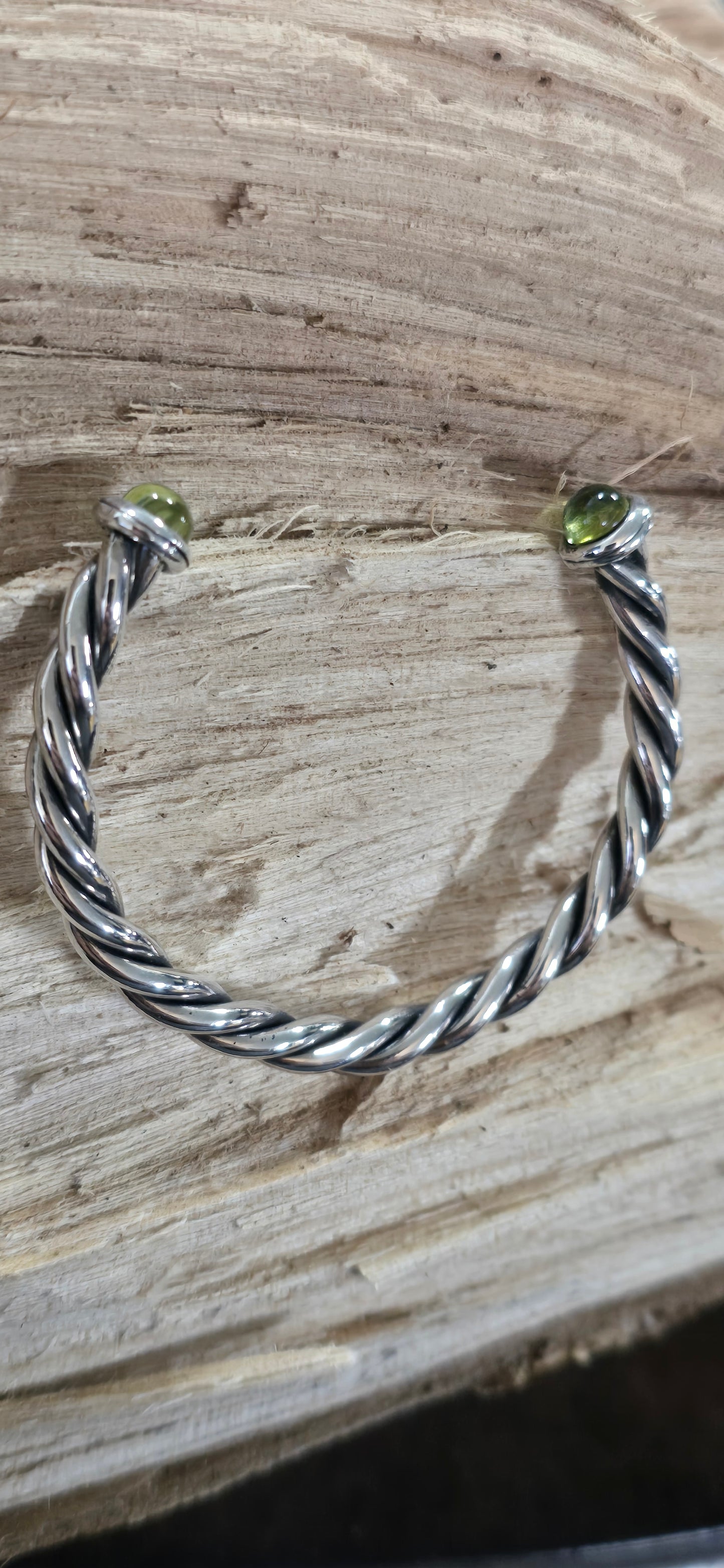 Twisted sterling silver oxidized cuff bracelet with cabachon peridot ends.